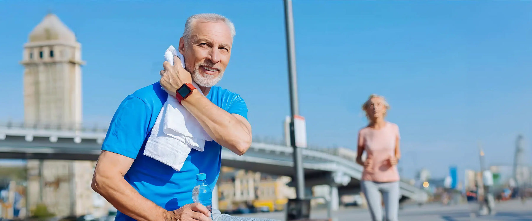 Senior man wiping sweat with towel after workout