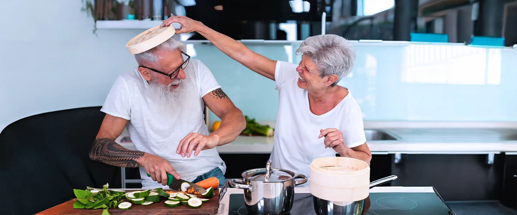 happy elderly couple meal prepping in kitchen