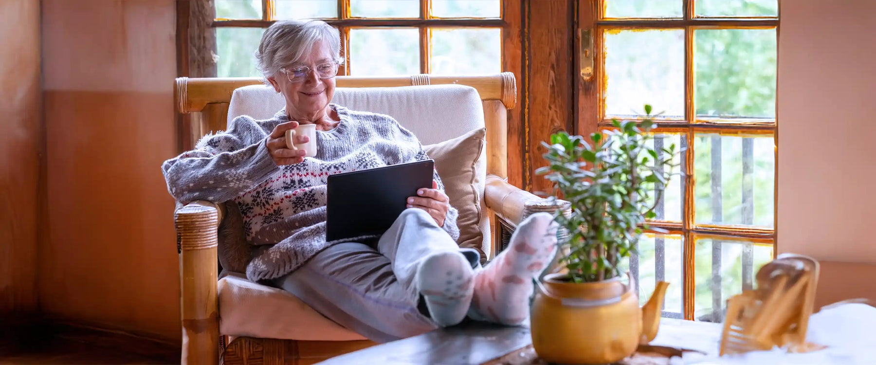Smiling relaxed pensioner woman sitting at home