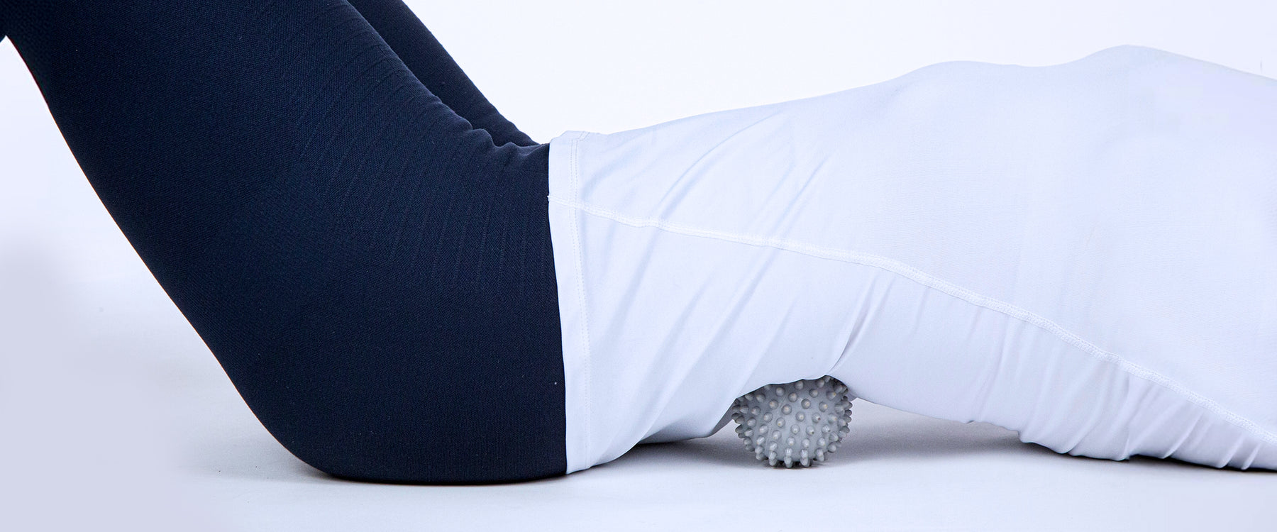 Woman's back massaging her back on the floor with spiked massage ball