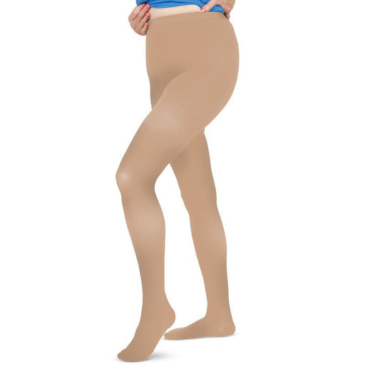 A pair of beige waist high compression pantyhose, displaying the front view on a model.